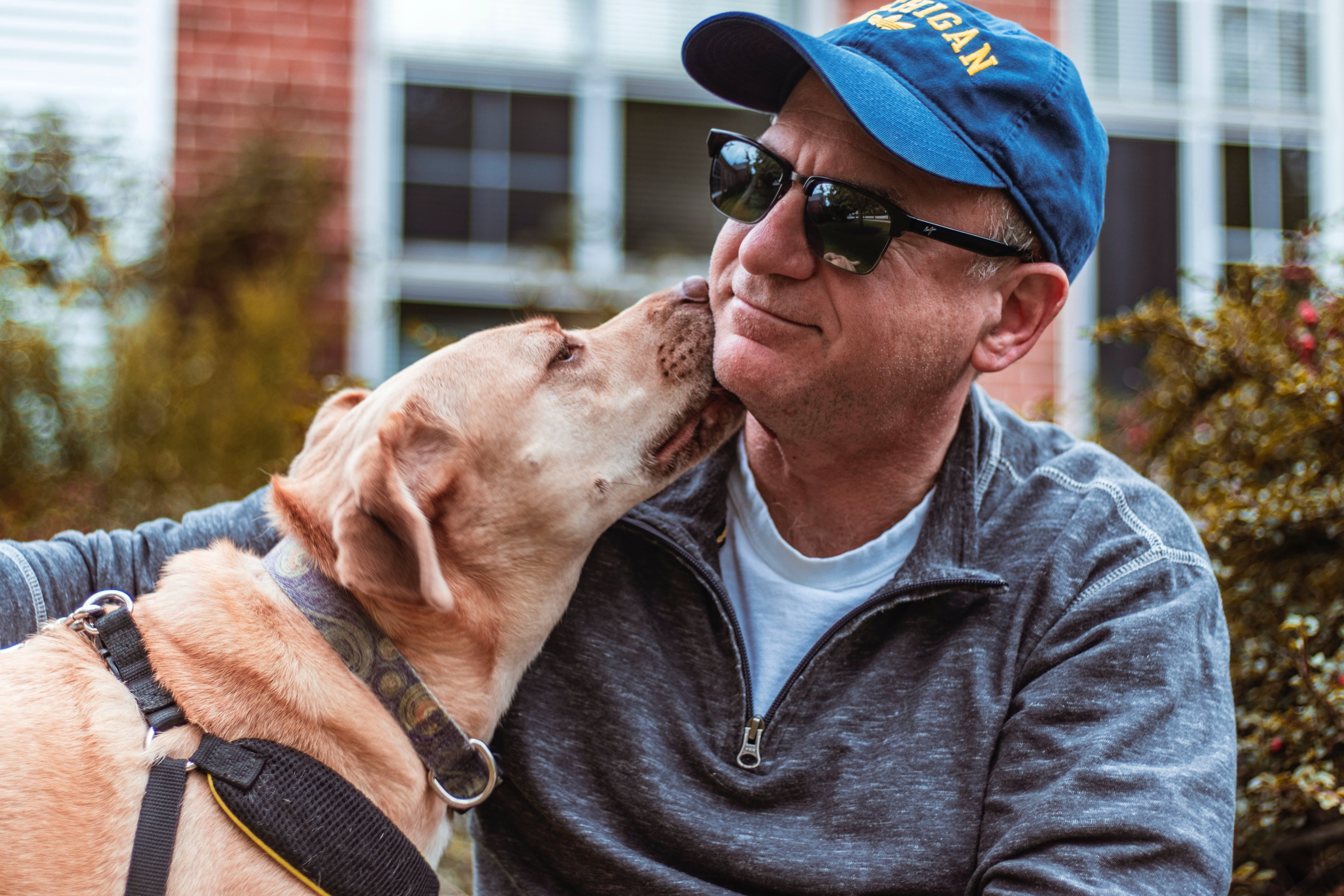 Man getting kissed by a dog on the cheek