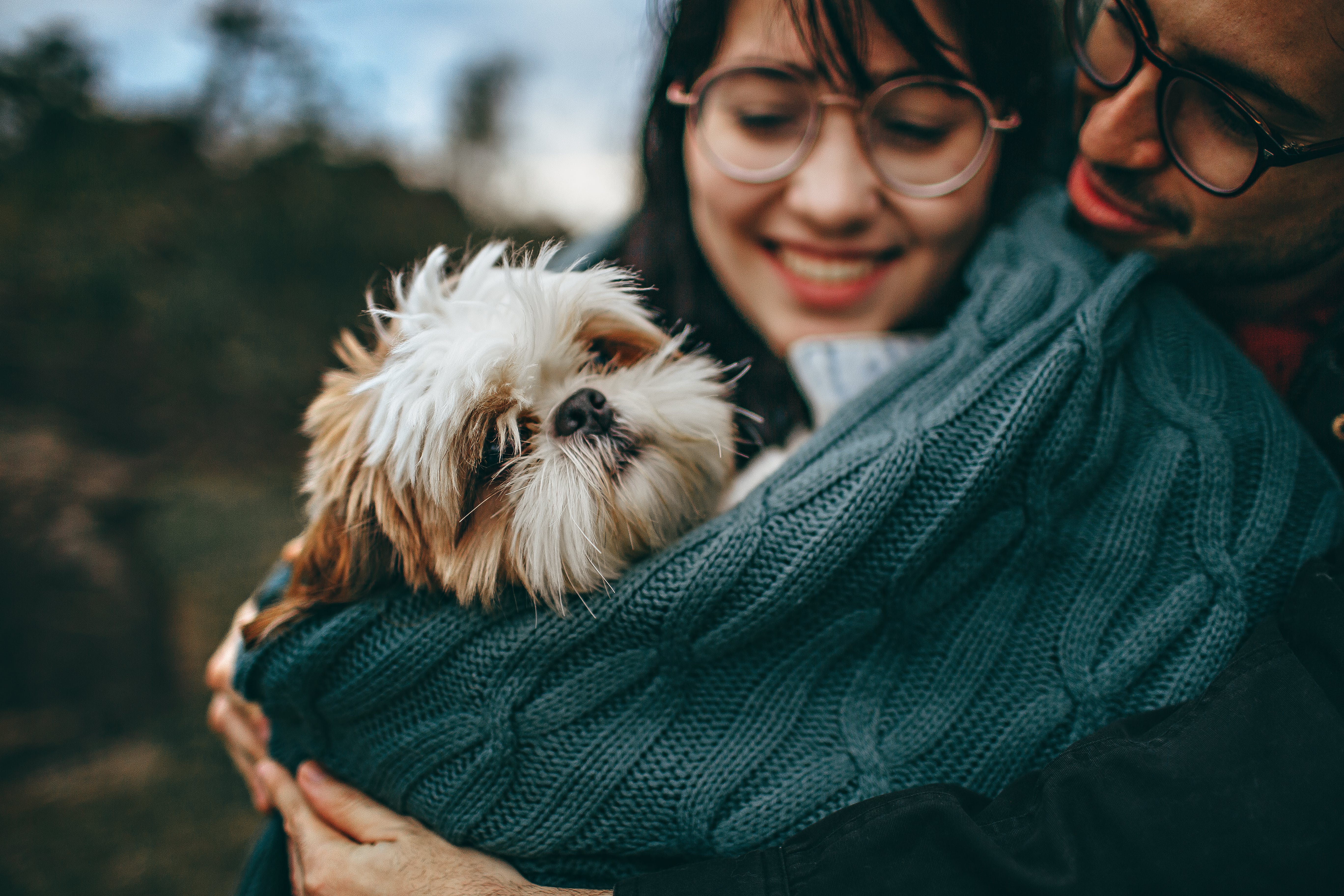 Two owners holding a shitzu